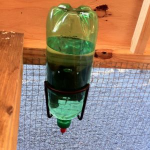 Bicycle water bottle bracket works perfect for a smaller 
coop style waterer. 

Gotta love the chicken nipples.

So easy and the girls love em ! 

Drill a small hole in top of bottle to vent air-lock.