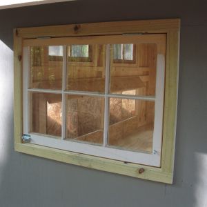 I used wood window sashes with hinges and slide bolts on all the windows.  Makes for easy access and good vents.   Chicken wire was installed on the inside of the windows above the nesting boxes so the sashes can stay open for ventilation.