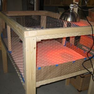 The brooder pen is constructed from 2x2s and 2x4s with 1/2" hardware cloth on the bottom and 1" chicken wire for the sides and top.  The whole top is hinged.  I would make the top in two halfs next time for easier access.  I used rosin paper on the floor with about 1" of sand on top of that. Sand was cheap and easy to clean.