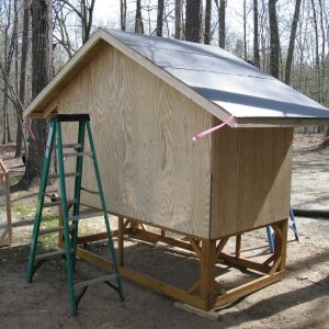 The coop is 4' x 8'.  The end walls are 4' high and the sides are 6' from bottom of floor framing to the peak of the gable.
The coop sits on a 2' high pedestal but I would make the next one 3' high to avoid hitting your head on the sharp roof panels.