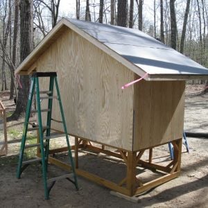 The coop is 4' x 8'.  The end walls are 4' high and the sides are 6' from bottom of floor framing to the peak of the gable.
The coop sits on a 2' high pedestal but I would make the next one 3' high to avoid hitting your head on the sharp roof panels.