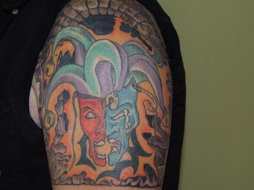 rolling stones tongue tattoo. It has a stone wall behind it.