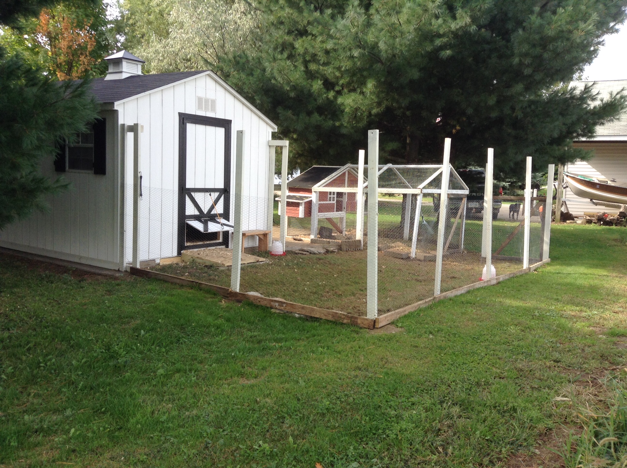 Fenced run attached to small coop.