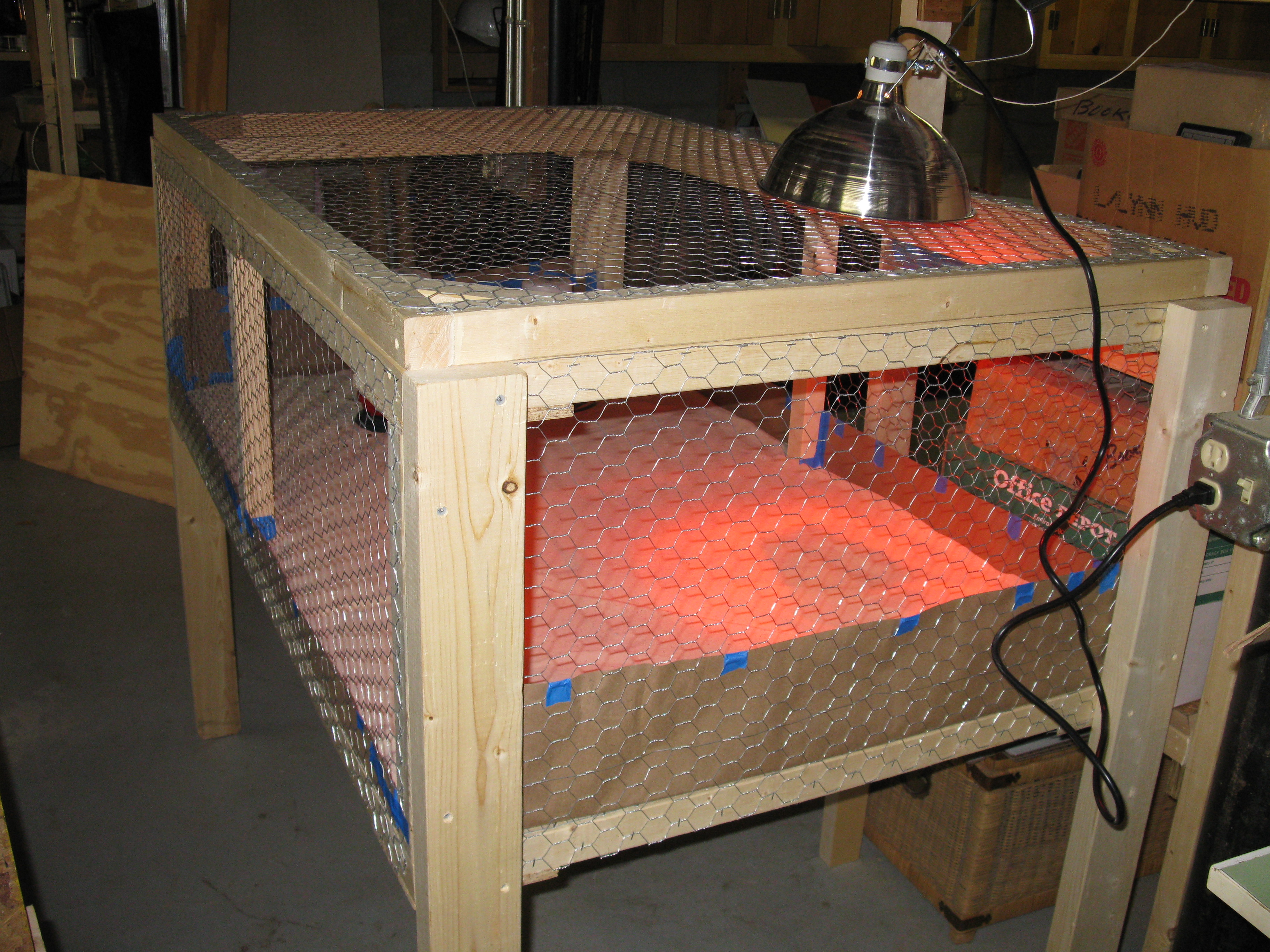 The brooder pen is constructed from 2x2s and 2x4s with 1/2" hardware cloth on the bottom and 1" chicken wire for the sides and top.  The whole top is hinged.  I would make the top in two halfs next time for easier access.  I used rosin paper on the floor with about 1" of sand on top of that. Sand was cheap and easy to clean.