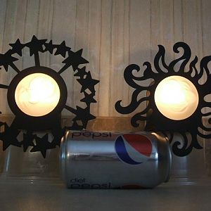 Sun and Moon candle wall sconces
black metal around the outside, glass smiling face in the middle
stick off the wall about 3" or so
The candles are lit and the room lights are off in this pict