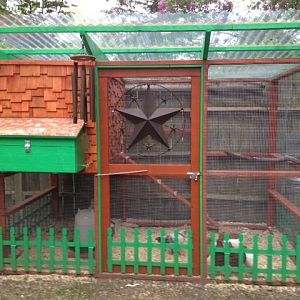 This is the front view of our coop.  It is built from plans from "The Garden Coop", which we used as a guide and embellished to our liking.  Modifications we made are the nesting box on the front of the house with a copper roof, cedar shake shingles, picket fence, and the hen door coming out the side.