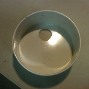 Materials needed:  1- 4" PVC (DWV) sanitary tee, a length of 4" DWV (whatever length you desire, 2- 4" DWV Flat end caps, 1- Clean-out fitting with cap, 1- toilet fill valve.

1. Drill a 1" hole in one of the end caps. Center of hole is 1" from edge of cap.