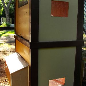 back of the coop, opposite of the door
