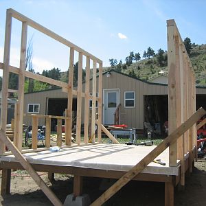 After the frame was finished we used some recycled 3/4" plywood for the floor and covered that with linoleum.  We then built the frames for the walls on the floor and stood them up and attached them so they didn't fall back over!