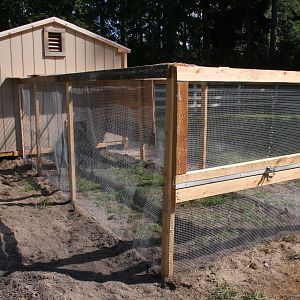 New coop with concrete anchors and  1/2" hardware cloth all around, buried 12" deep to avert another dog attack.
