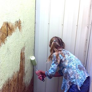 Jessie helping paint the outside wall