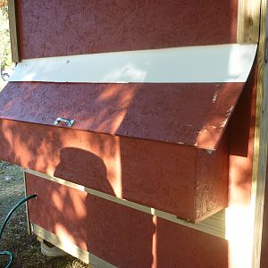 This is another view of the back of the coop.  The door can be raised to remove the eggs from the nesting boxes.  Notice the white plastic that was installed under the siding and over the door to prevent the rain from running into the nests.
