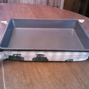 John Deere patterened with green, brown, and peach floral on off-white background lining. Brown ribbon.