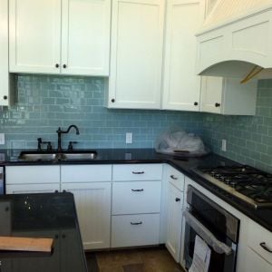 A glass subway tile backsplash in the same house with the slate floor.