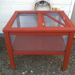I built this brooder by transforming a table base I found at a thrift store ($7). I added the platform in the middle, which sits on support boards. The top I constructed from 2x4s and materials I found around the farm. There is hardware mesh surrounding on all sides and top. It is stained with leftover fence & wood stain.. It turned out great! Later, I also added roosts and built in electrical lamp sockets for heat lamps.