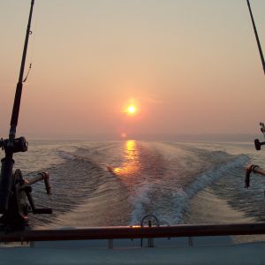 SAME SUN COMING UP BETWEEN DOWNRIGGERS & POLES ON WHITE LAKE