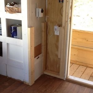 Automatic chicken door is made from old plastic cutting board that glides in grooves of a routed 2x4 track.