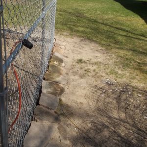 Flat rock covering the perimeter with twelve inches of poultry fence buried below the chain link.