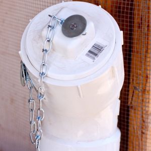 The "inventions" thread provided me with some outstanding ideas.  I took the PVC feeder "idea" and added a twist of my own--a threaded clean-out plug cap, threaded clean out plug, and a chain to keep the cap from getting lost in the deep litter.