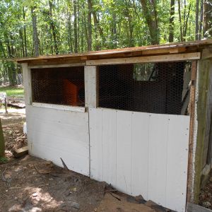 The outside of the coop. The windows are covered with wire.