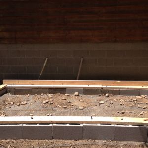Put 1/2x1/2 hardware cloth on the ground to keep predators out. Hollow blocks then placed 2x6 wood for the foundation.