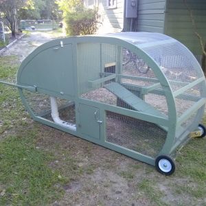 the new coop. the door on this side opens to a water bucket with nipples hanging out the lower level. and the top of the PVC pipe you put the food in.