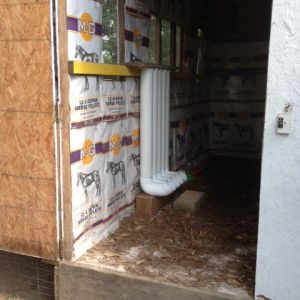 inside my hen house.... showing feed-sack wallpaper decor, and PVC pipe feeders