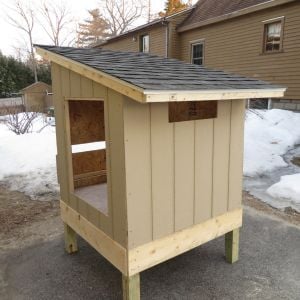 Another day of work and the roof is on. This is pretty much traditional roofing technique, plywood over a 2"x3" lumber frame, then a layer of tarpaper, then asphalt shingles.