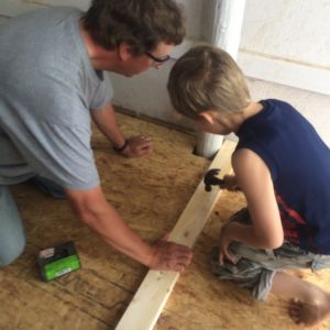 Plywood was laid over the pallets for a floor. My husband and 8-year-old son are installing the door frame.