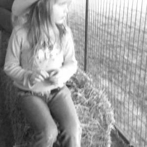 Dani watching her Daddy train horses.