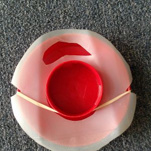 Place rubber band on waterer base as shown, so it's opposite the slot on the top.