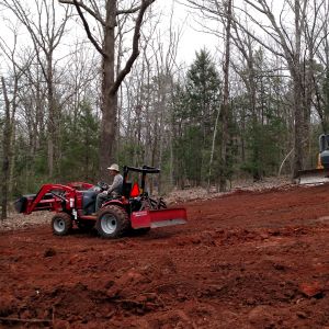 Grading pad site.  Going to put up a 40'x80' main structure with 10' wrap around porches and about a 7/12 roof pitch.  It is located on a hill.  Going to be a walk out with a loft.  Posts for main structure going in within a month.