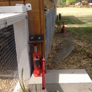 We inserted a jack under the metal support attached to the coop so we can raise the coop up so it is not sitting on the entry way to the run and we can pull it out.