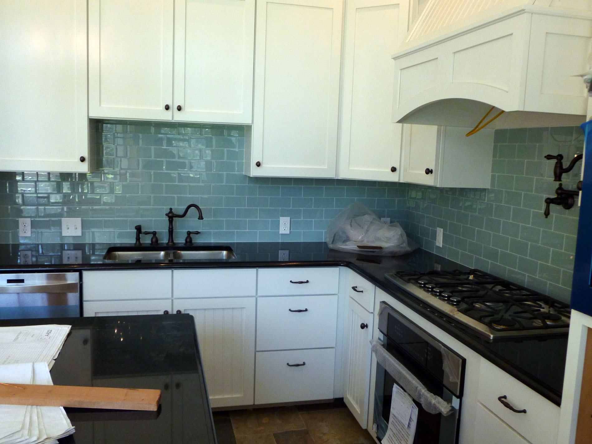 A glass subway tile backsplash in the same house with the slate floor.