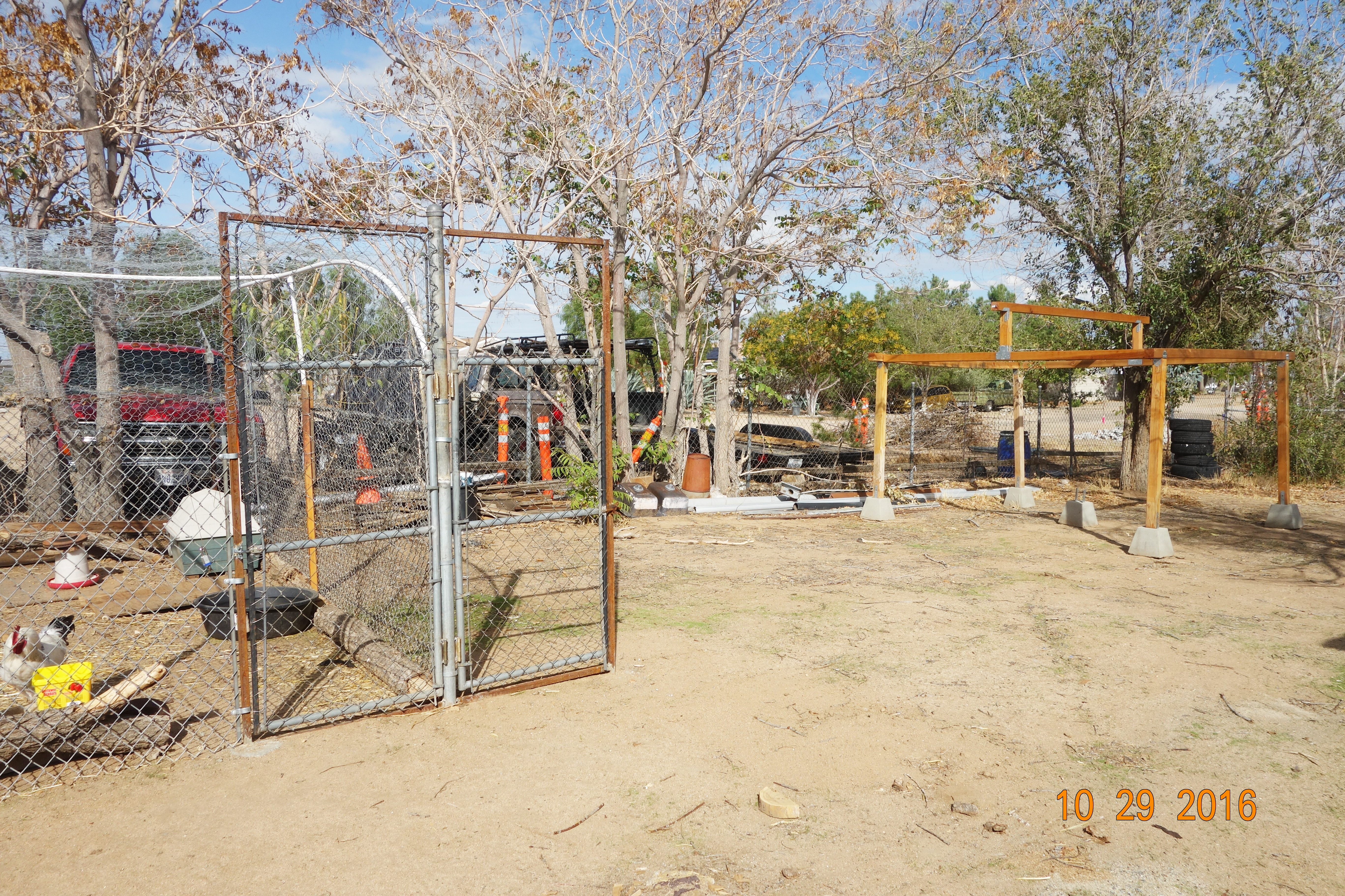 A separate gate on the right side of the chicken run gate is for a future run for another livestock, possibly for goats.
