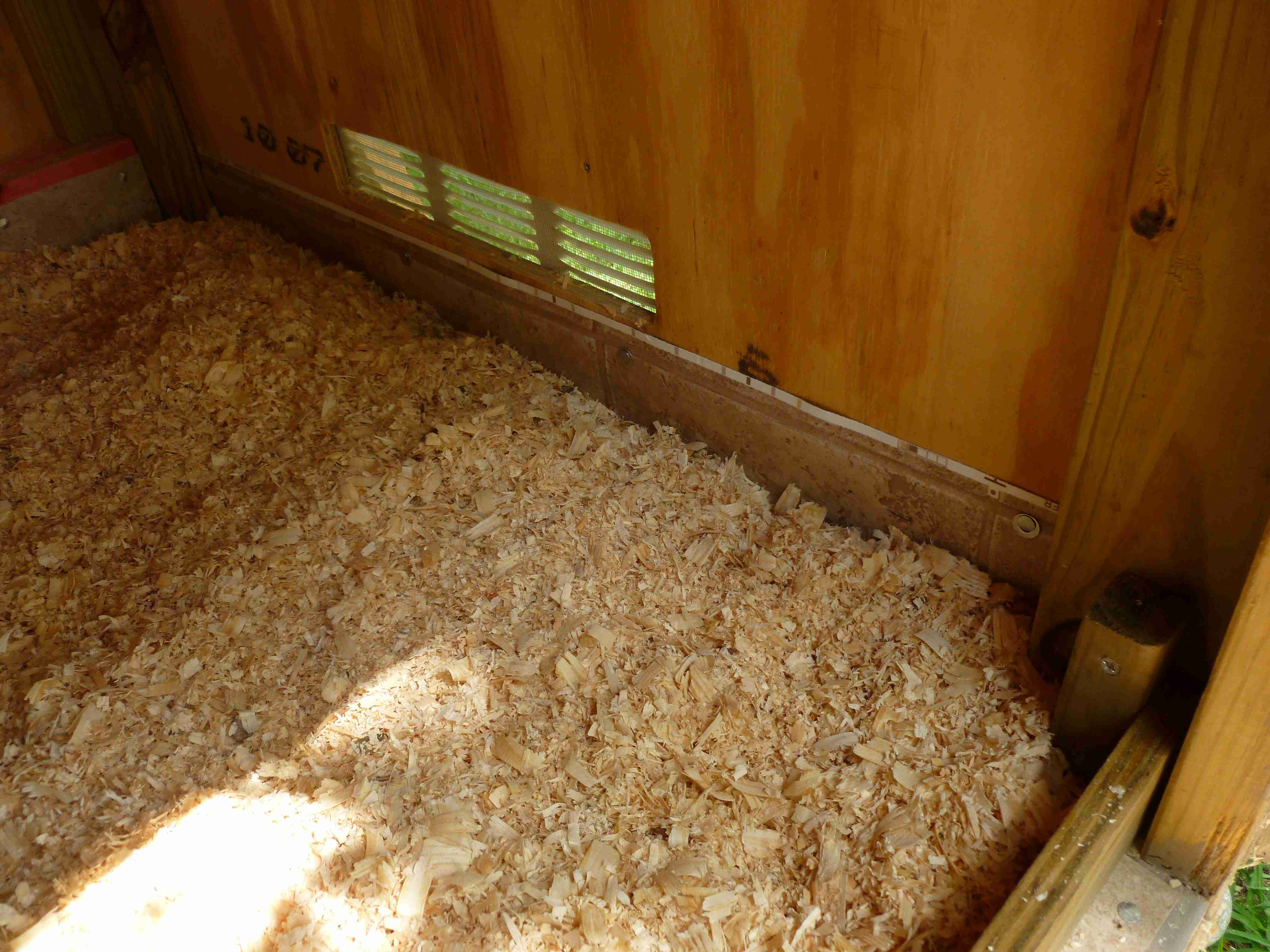After installing the vinyl, added a drop board across the door opening to help retain shavings.