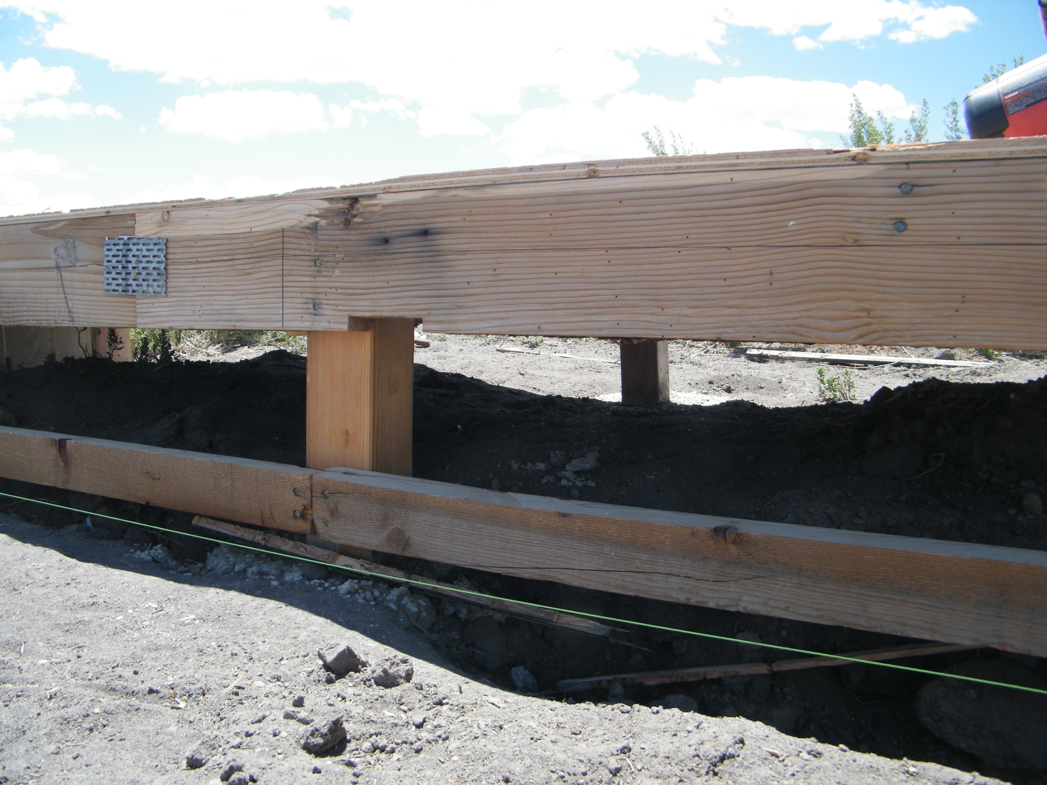 After putting on the floor this day and collapsing from exhaustion and sunburn in the late afternoon, I realized that I made quite a mistake.  See the two posts in this shot?  There should be a dividing fence line under there, the same as in each end, shown in the current album cover.  So, I get to cut and remove a four foot section of my flooring so that I can get to this area to install the divider.  Fun for me!