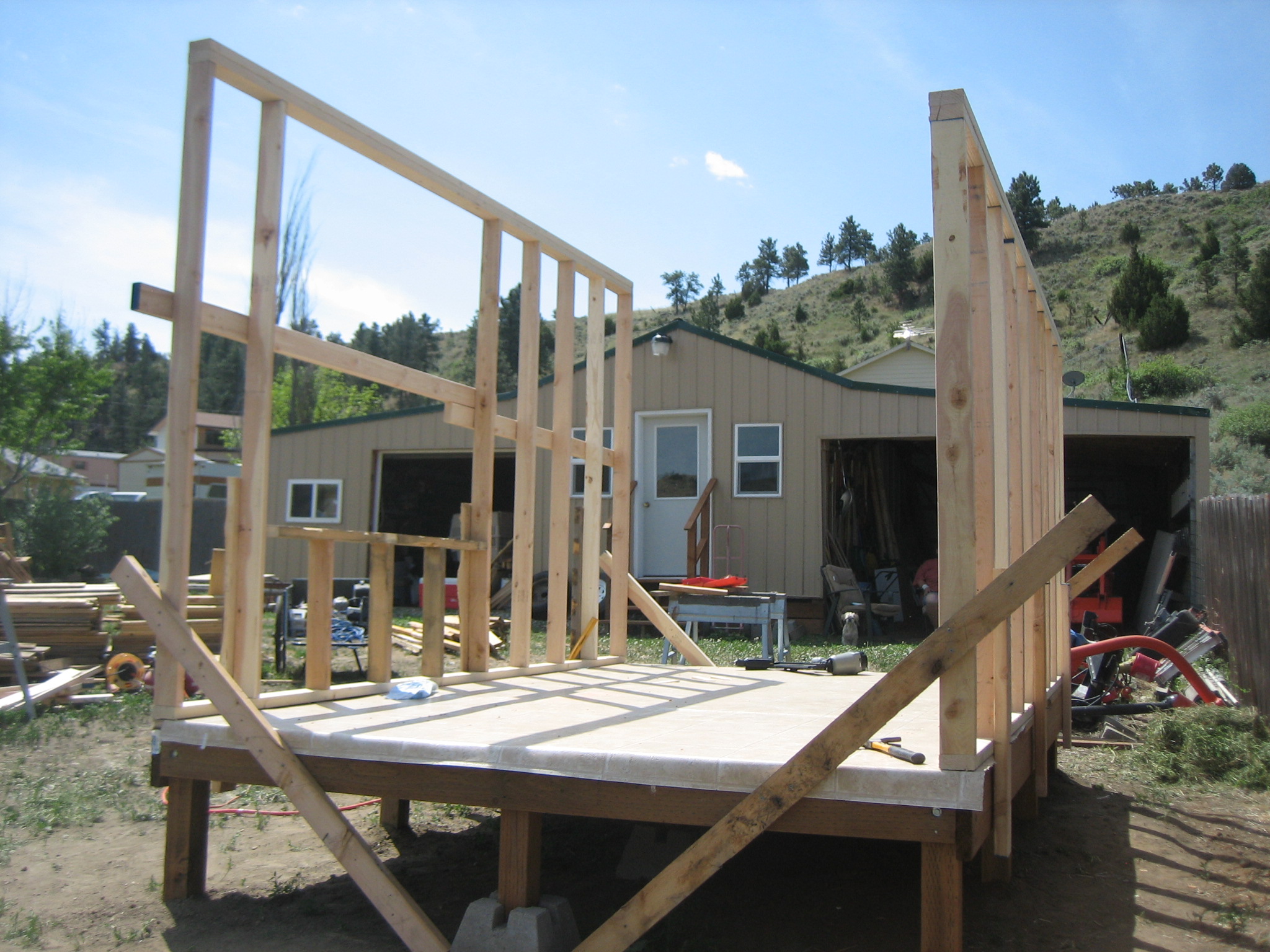 After the frame was finished we used some recycled 3/4" plywood for the floor and covered that with linoleum.  We then built the frames for the walls on the floor and stood them up and attached them so they didn't fall back over!