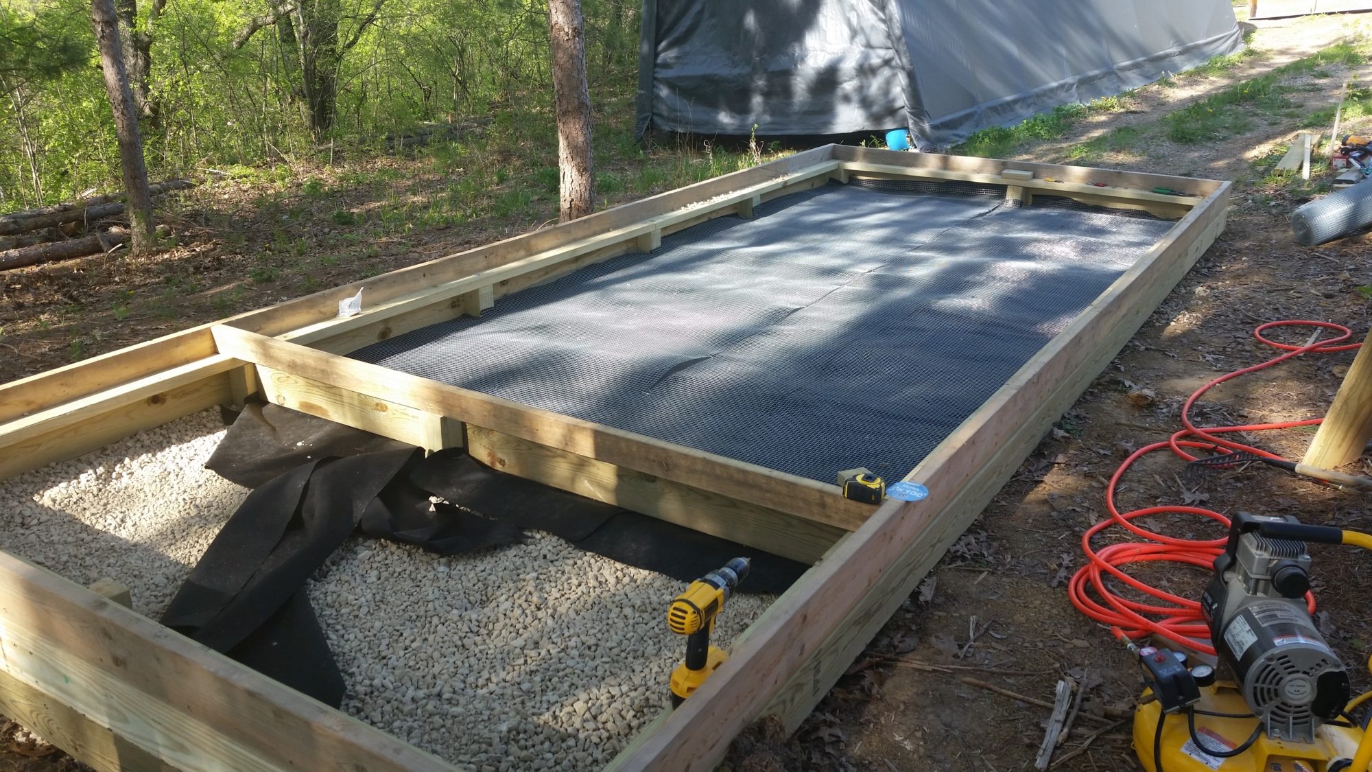 After the gravel was set and leveled, I covered with heavy landscape fabric, followed by a layer of 1/2" hardware cloth.  Nothing is digging its way in to this coop!  Much sand was then added on top of the hardware cloth in the run.  The small gravel area is the crawl space under the storage section.  I added vents in the sides to keep moisture from becoming a problem under the floor.