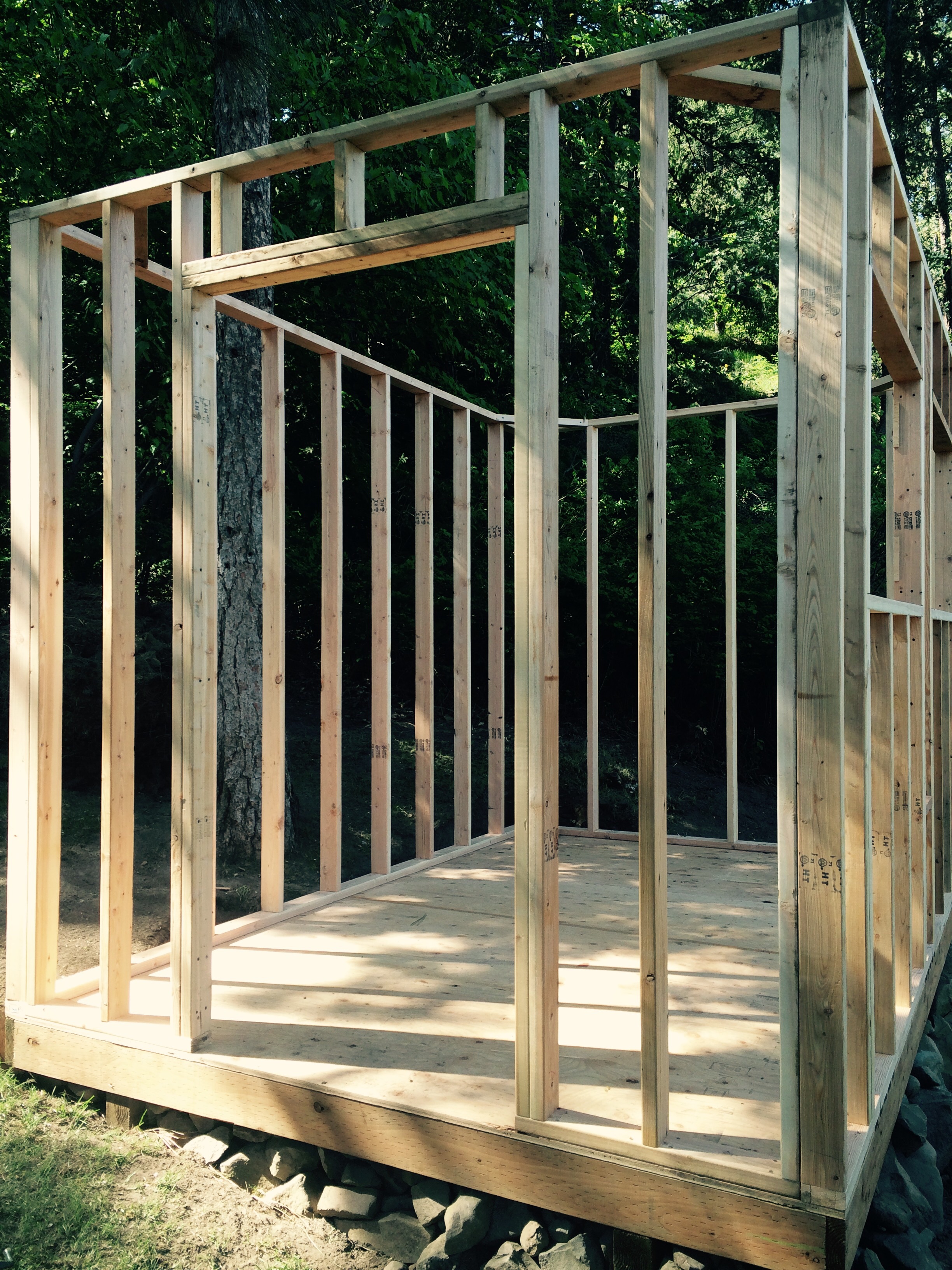 All four framed walls with door and window openings.