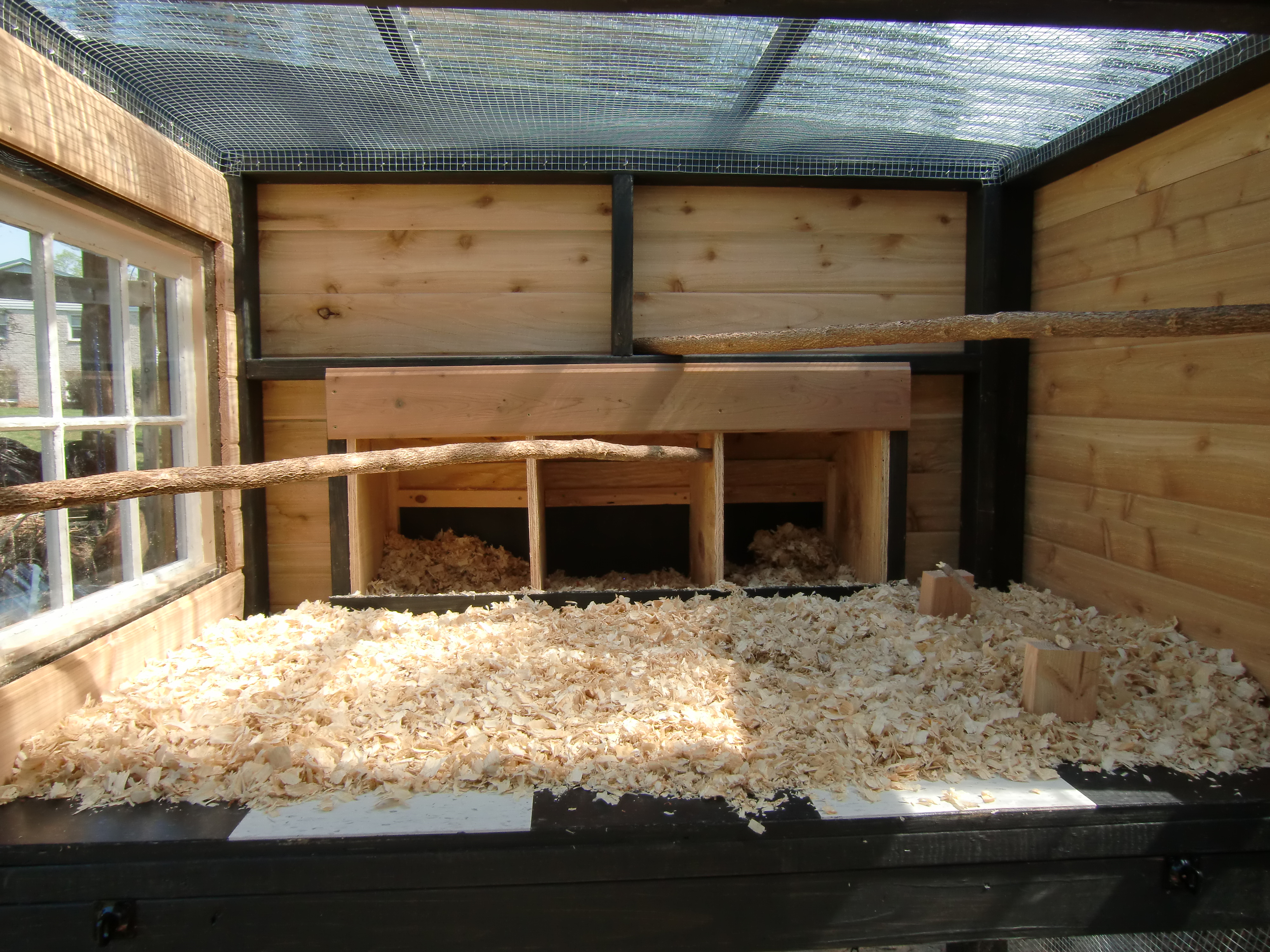 All perches are natural branches for better traction. They are arranged at angles to allow for the side to swing up for cleaning.