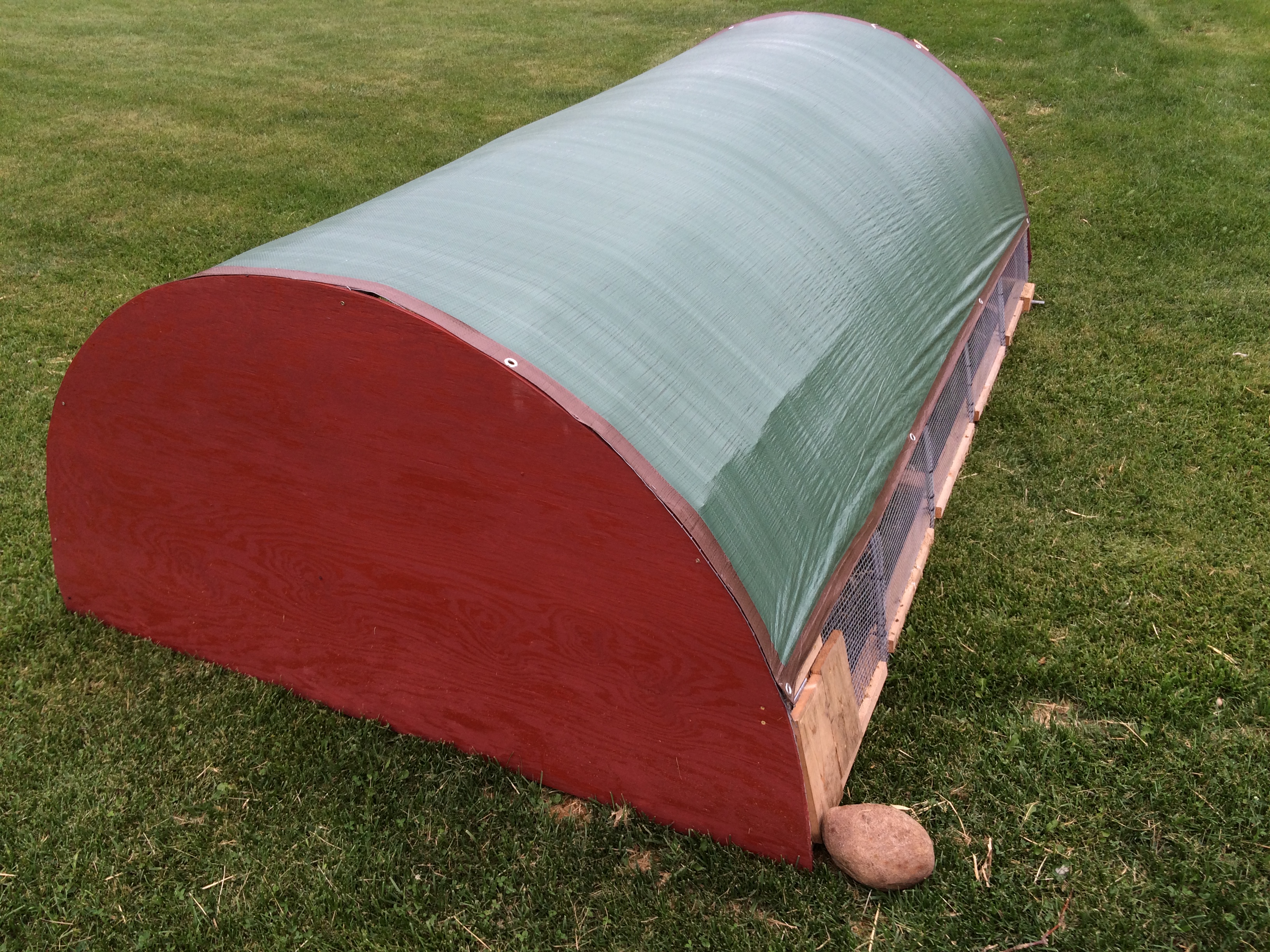 An outside view of the hoop tractor.  The flap for the feed trough is visible lower right.
This photo is before i attached a permanent latch to the flap.  a rock was initially used to block the flap