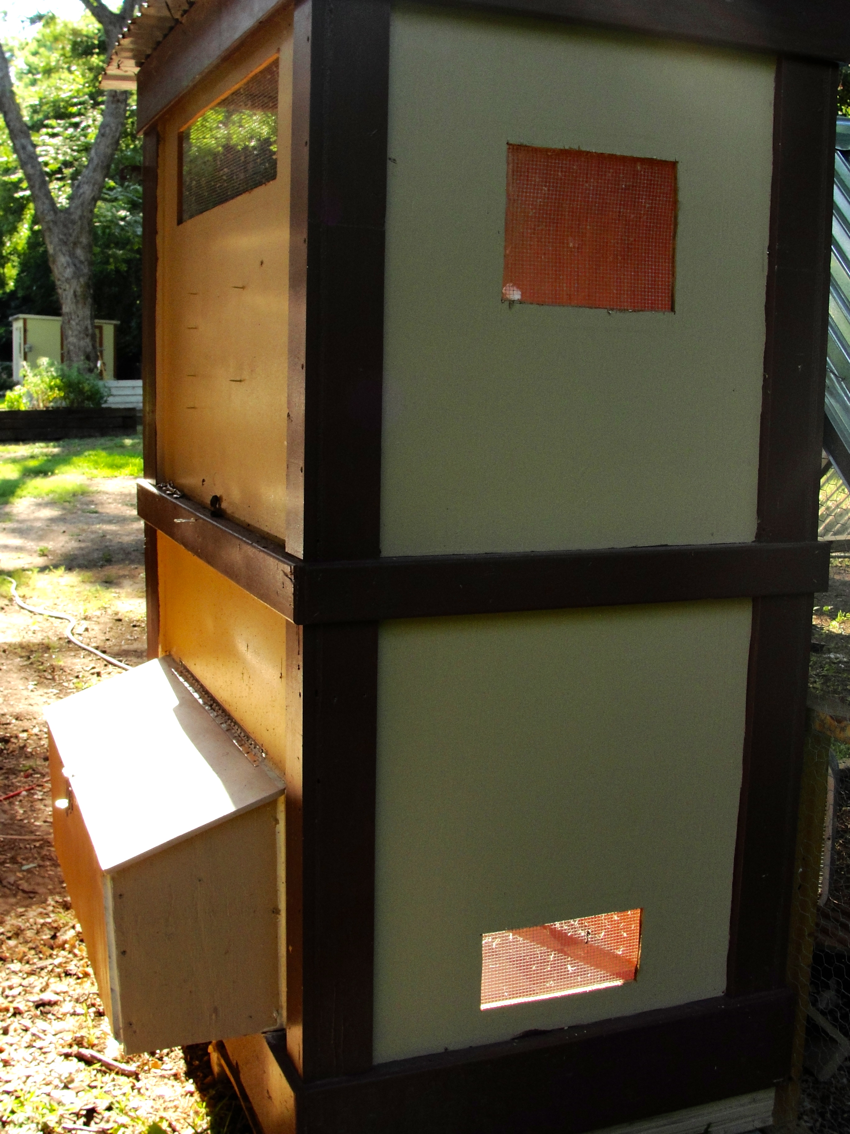 back of the coop, opposite of the door
