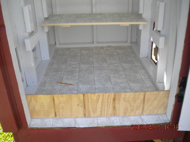 Board at entrance to keep bedding inside coop