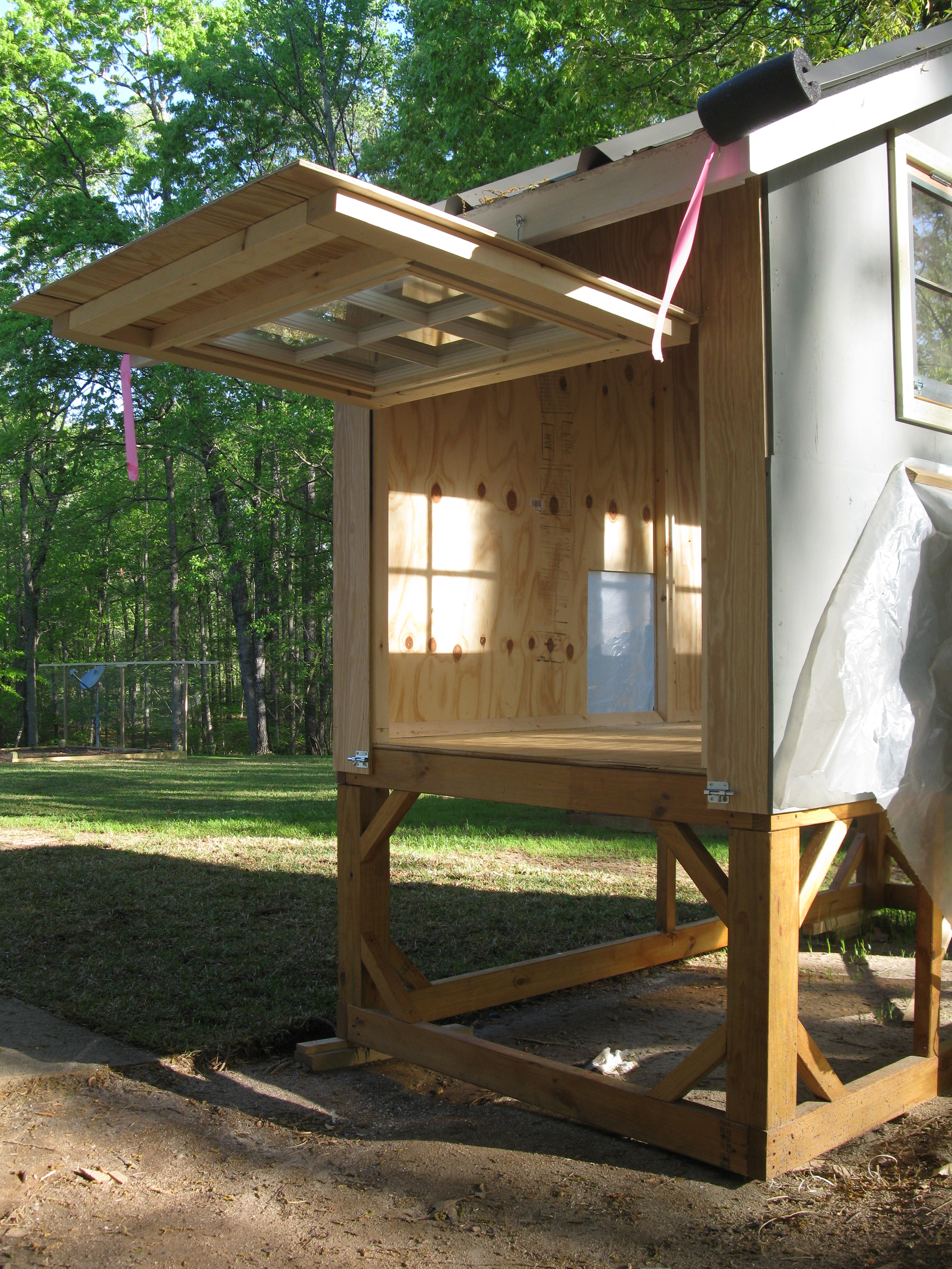 Cleanout hatch door with hinged window sash.  The black pipe insulation at the lower corners of the metal roof are there to keep you from hitting your forehead on the sharp edges.  I would probably raise the coop up one more foot if I had to build another one.