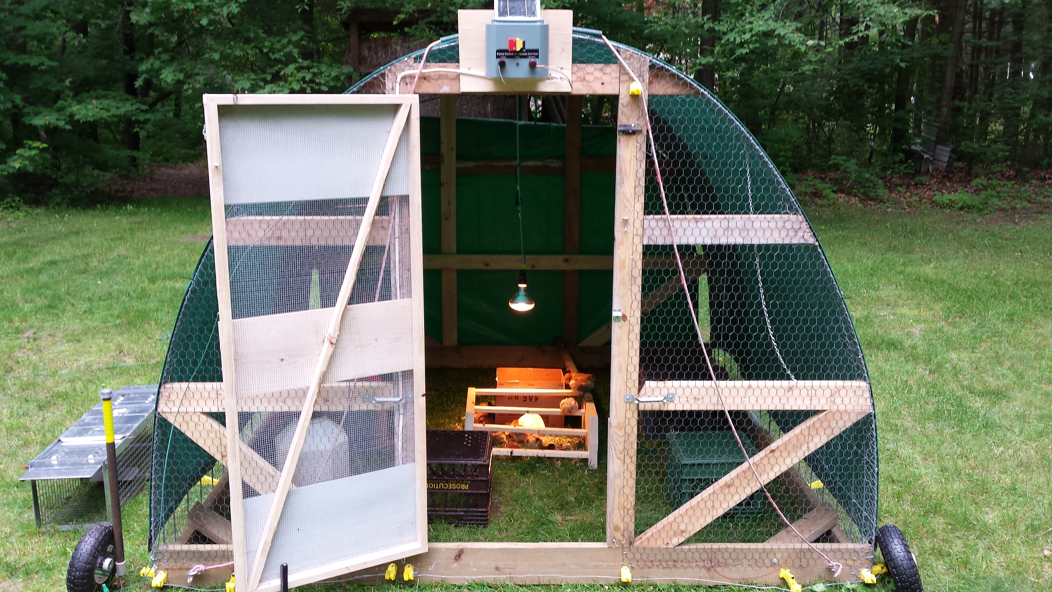 completed hen tractor with tarps and electric fence and charge controller, before removable wheels were added