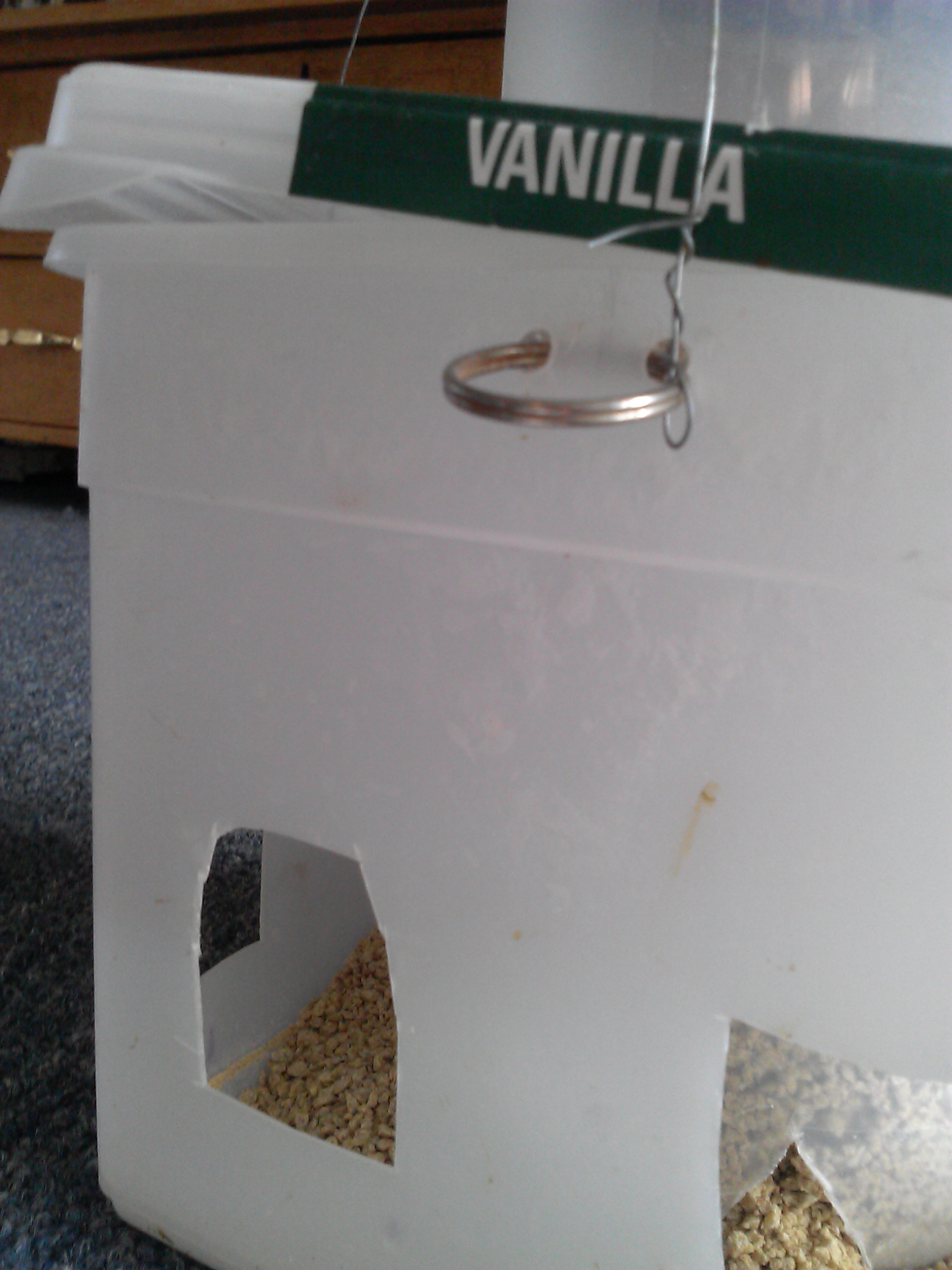 Cut "head holes" in bucket so chicks can access feed. Punch holes just under lid on all four sides to insert key ring for wire hangers.