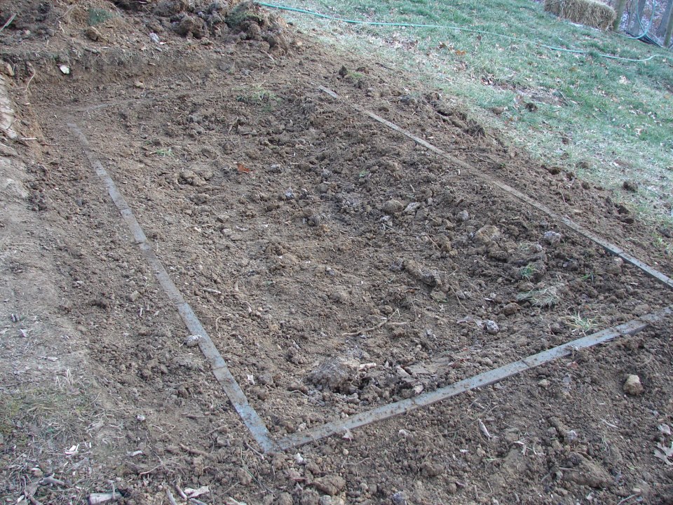 Filling in dirt around before setting foundation blocks.