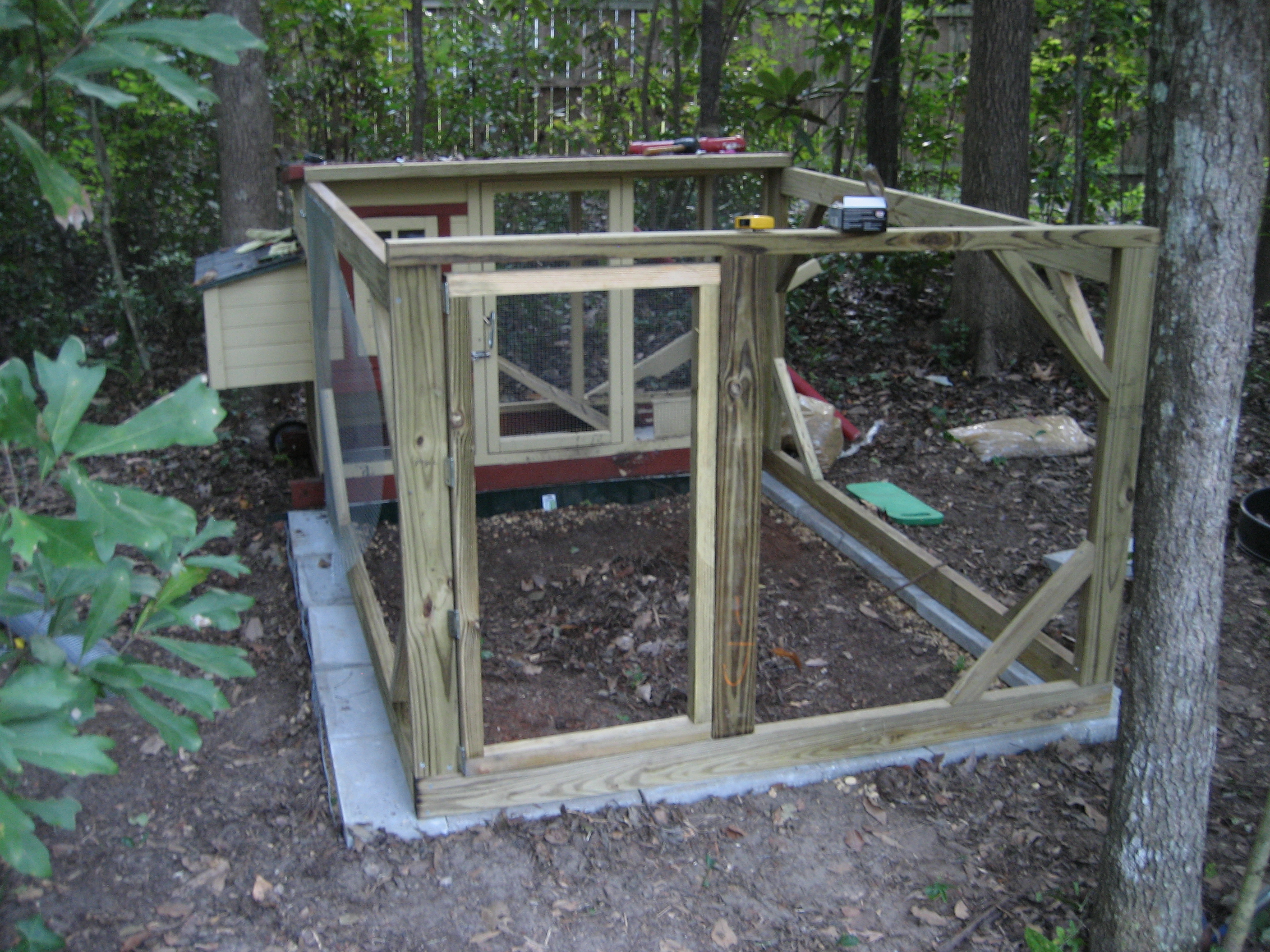 Final Frame - then he went home! 
There are 2 latches on the door, just in case. One screen door hook, and the other is a sliding latch. 
I painted it, then covered the entire frame in more hardware cloth. And staple-gunned the crap out of it. We were going to leave the entire top open but I decided they needed more cover from rain, and added a piece of plywood, which is extremely warped now. But it was a good move. 
The run is still just big enough that we can leave the girls in there for a day or two if we have to be gone and don't have anyone to let them in or out OR decide they need to be locked down for safety. 

The new front run is 77" L x 63" W x 44" H