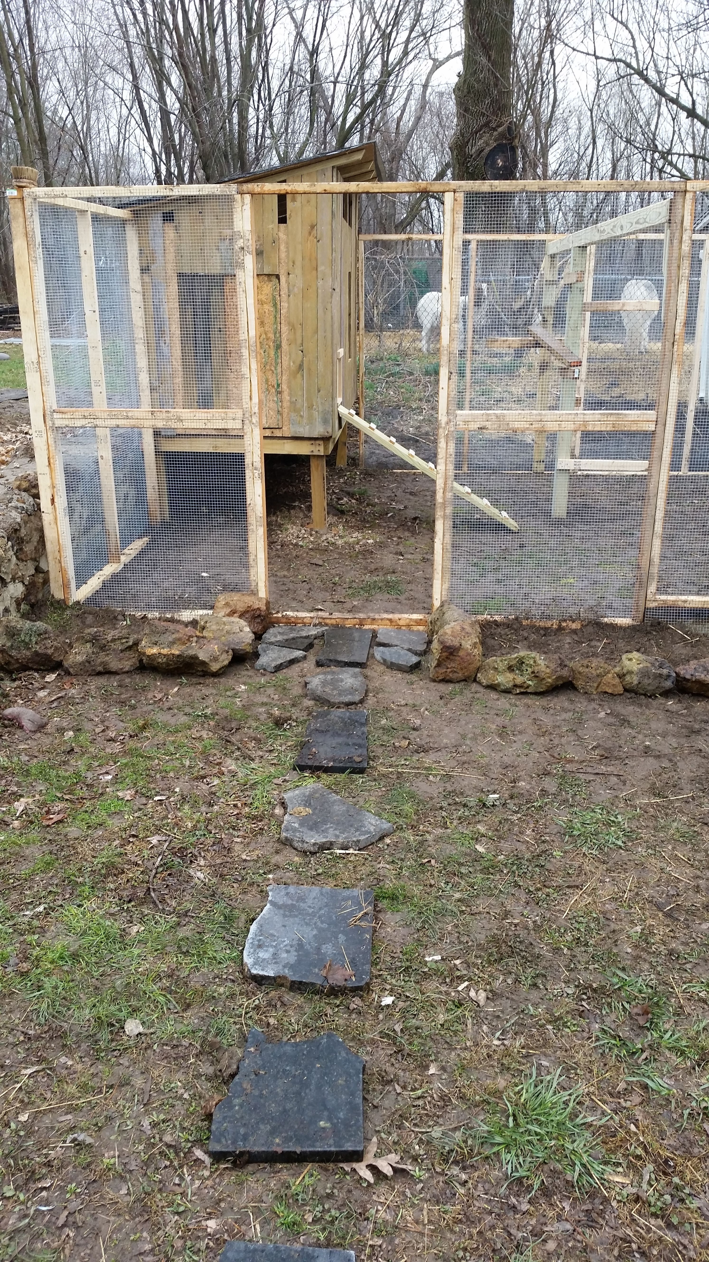 Front of the run (before door). We had a lot of rocks and a pile of chipped granite on the property so I utilized them here. The rocks were placed on the outer border of the 2ft hardware cloth skirt around the run. They will also serve as the border for a flower bed to add some color and charm to the area. The granite pieces were placed as stepping stones to the run door, but they are a bit slippery in the rain. I'm undecided right now if they will stay.